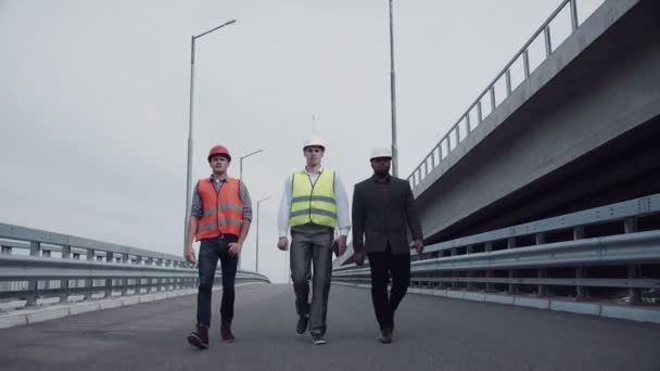 Ingenieros de construcción caminando en rampa de carretera — Vídeo de stock