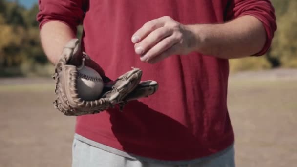 Un homme jette du baseball dans une main gantée — Video