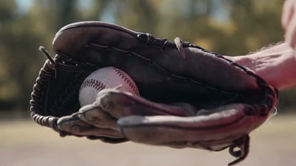 Бейсболіст, кидаючи м'яч у рукавичку — стокове відео
