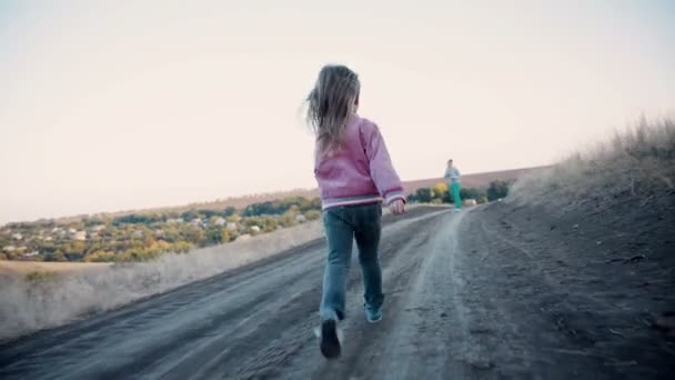 Petite fille marchant le long d'une route de campagne 
