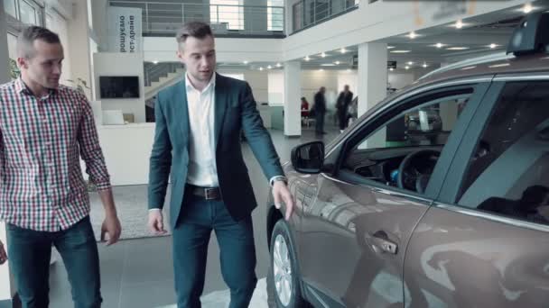 Verkoper presentatie van een nieuwe auto aan een klant — Stockvideo