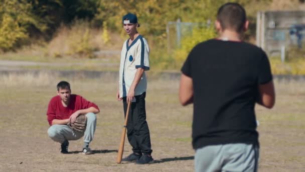 Hombres jóvenes jugando al juego casual de béisbol — Vídeo de stock