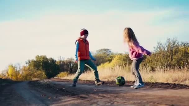 Dois irmãozinho e irmã jogando futebol — Vídeo de Stock