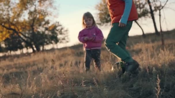 Ung pojke och flicka som leker fotboll landsbygden. — Stockvideo