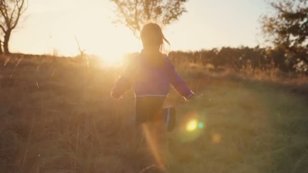 Menina loira jovem correndo ao pôr do sol — Vídeo de Stock