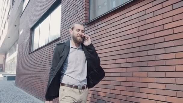 Businessman walking along the brick wall. — Stock Video