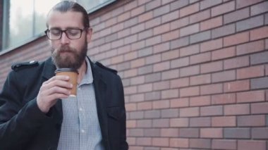 Şehirde yürürken kahve içme sakallı.