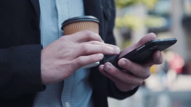 Mann schreibt SMS mit einer Tasse Kaffee in der Hand — Stockvideo