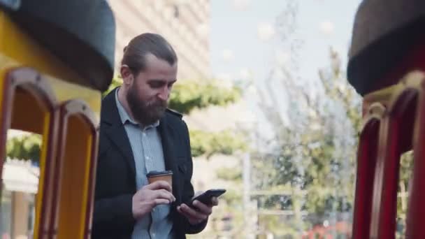 Wysyłanie SMS-ów człowiek z filiżanką kawy w ręku — Wideo stockowe