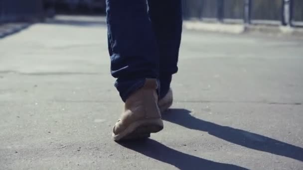 Homem de botas amarelas caminha por todo o ambiente urbano — Vídeo de Stock