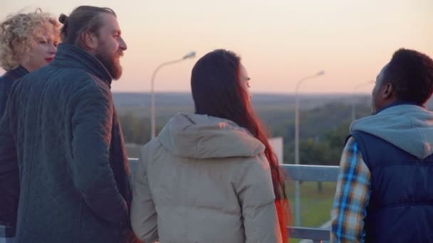 Quatro amigos pendurados na ponte à noite . — Vídeo de Stock