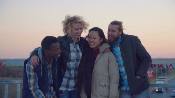 Ποικιλόμορφη οικογένεια τέσσερις stand στο κιγκλίδωμα και γέλιο — Αρχείο Βίντεο