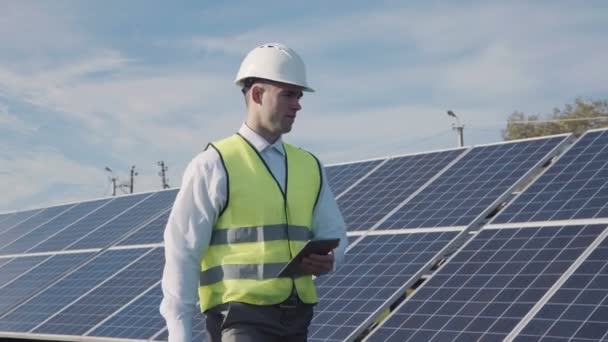 Technicien marche à côté de la gamme de panneaux solaires — Video