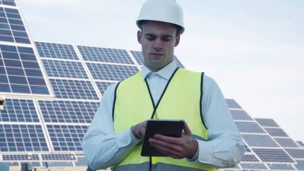 Solar panel technician using tablet near array — Stock Video