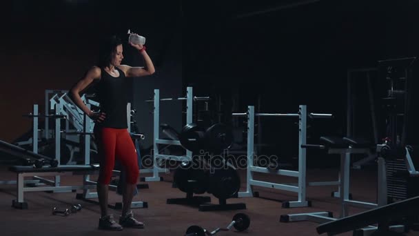 Attractive pouring bottle of water on herself — Stock Video