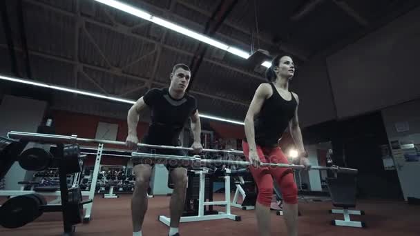 Сильная спортивная пара тренируется в тренажерном зале — стоковое видео