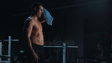 Güçlü genç atlet kapalı spor salonuna towelling tonda