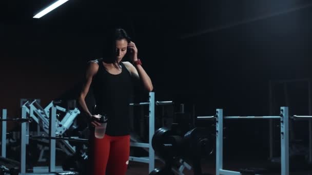 Спортсменка п'є воду в спортзалі і тренуваннях — стокове відео