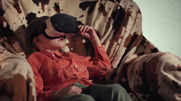 Garçon regardant à travers casque VR et gesticulant — Video