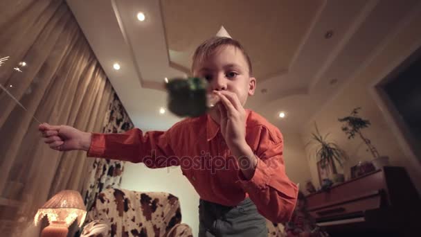 Jongetje holding sparkler en blazen van de fluit — Stockvideo