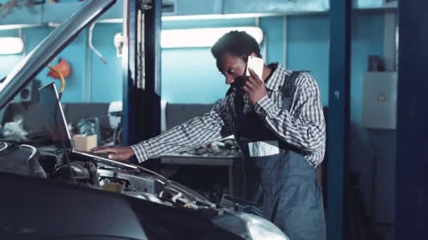 Homem falando telefone e fazendo diagnóstico do motor — Vídeo de Stock