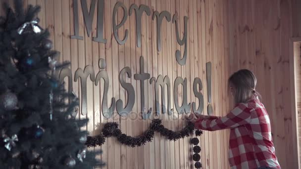 Молодая женщина ставит рождественские украшения — стоковое видео