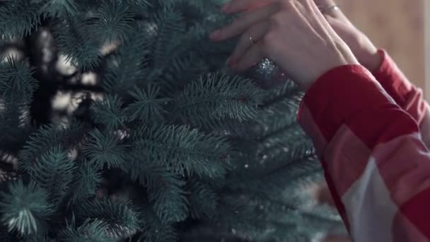Mulher colocando bolas na árvore de Natal — Vídeo de Stock