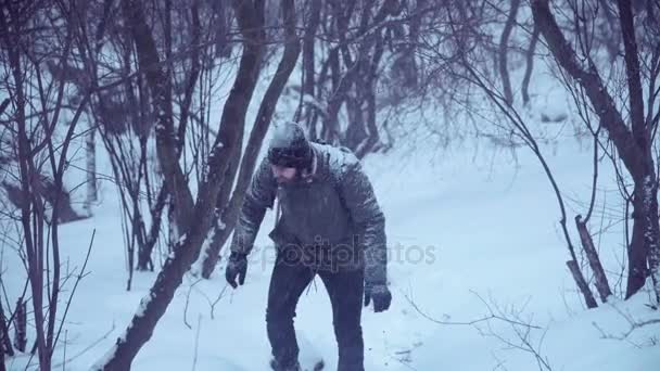 Man klättrar upp snöig backe — Stockvideo