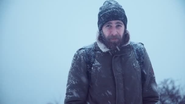 Улыбающийся мужчина с бородой в снегу — стоковое видео