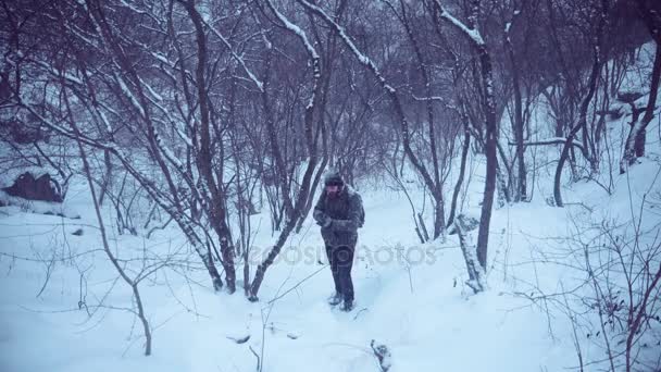 男人在白雪皑皑的树林里徘徊 — 图库视频影像