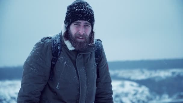 Hombre serio con barba en la nieve — Vídeo de stock