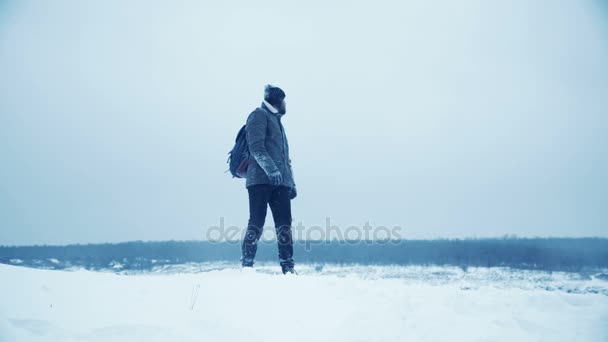 Человек бродит на улице зимой — стоковое видео
