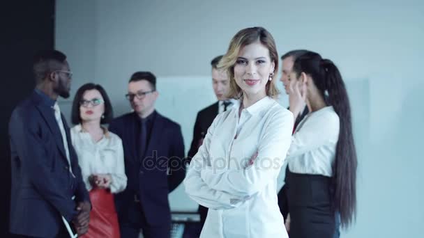 Mujer sonriente mirando hacia atrás a sus colegas — Vídeo de stock