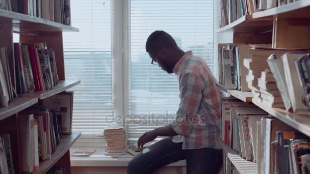 Hombre afroamericano con libros en la ventana — Vídeos de Stock