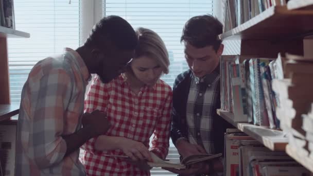 Mensen bespreken boeken tussen stapels — Stockvideo