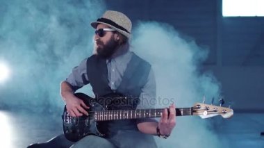 Şapka kapalı performans gitar çalan