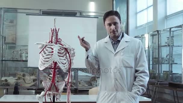 Professor médico em aula de anatomia com esqueleto — Vídeo de Stock