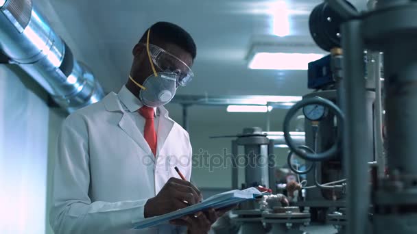 Cientista mascarado a escrever em laboratório — Vídeo de Stock