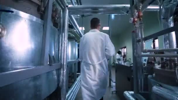 Мужчина-ученый, проходящий через лабораторию — стоковое видео