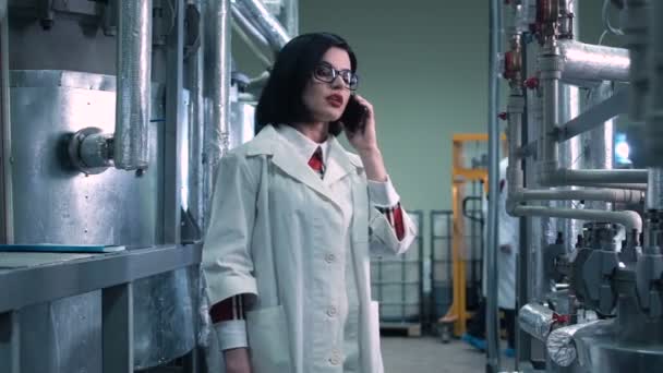 Donna scienziata che riferisce sul suo telefono in laboratorio — Video Stock