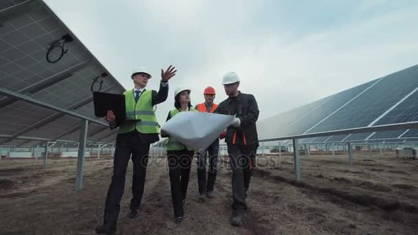 Gente caminando en paneles solares y hablando — Vídeo de stock