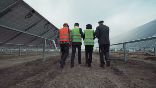 Menschen gehen in Sonnenkollektoren weg — Stockvideo