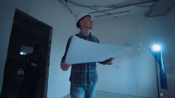 Man on a site with blueprint — Stock Video