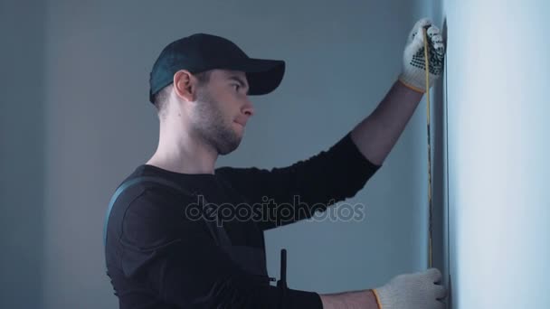 Man measuring wall on construction site — Stock Video