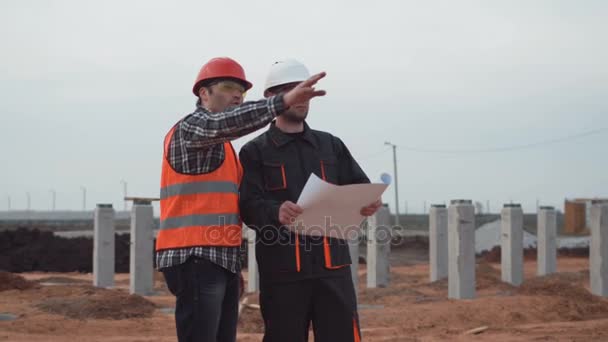 Hombres en uniforme cerca de columnas discutiendo el plano — Vídeos de Stock