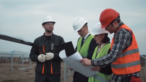 Grupo de engenheiros ou técnicos em uma fazenda solar — Vídeo de Stock