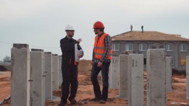 İşçi kalite ve ölçüm tartışırken sütunları yakınındaki