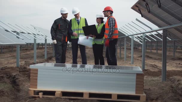 Ingenieros con plano y portátil en granja solar — Vídeo de stock