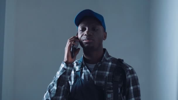O construtor africano falando telefone no local — Vídeo de Stock