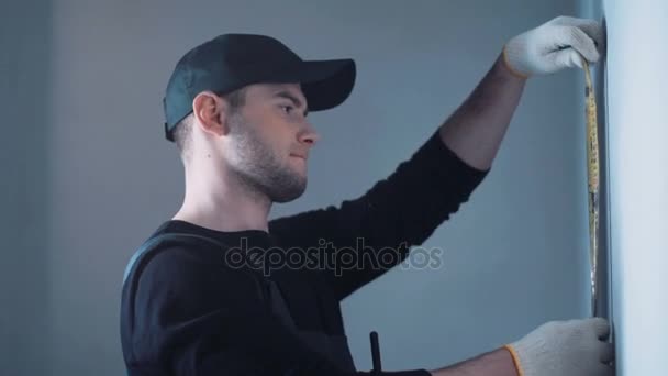 Homem de parede de medição no canteiro de obras — Vídeo de Stock